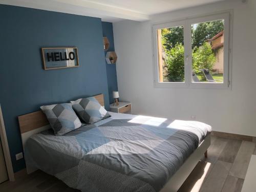 圣雷热雷梅累兹L'escapade的一间卧室配有一张蓝色墙壁的床和一扇窗户