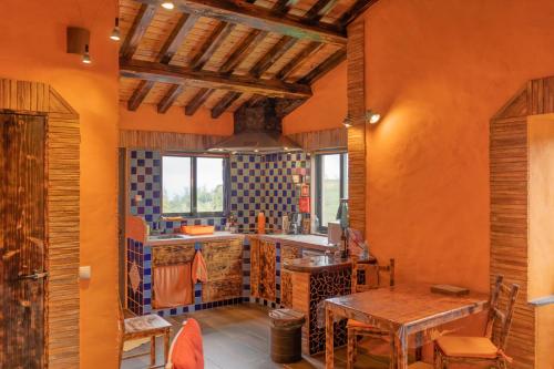 Lajes das FloresCasa Boa Onda的厨房设有橙色墙壁和木桌