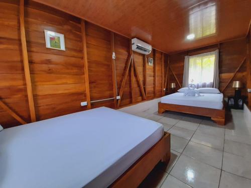 福尔图纳Cabaña Rural el Mirador的木墙客房的两张床