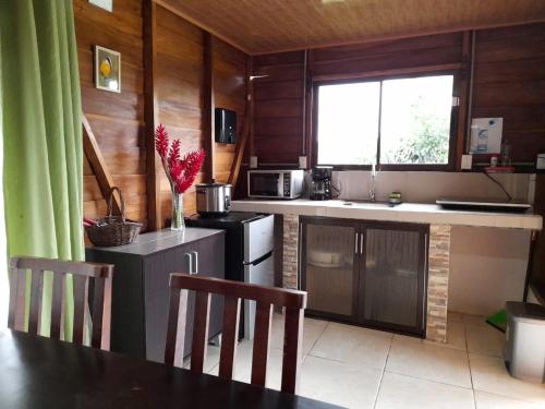 福尔图纳Cabaña Rural el Mirador的厨房设有木墙和桌椅