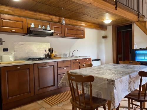CasoliVilla dei Vasari的厨房配有桌椅和炉灶。
