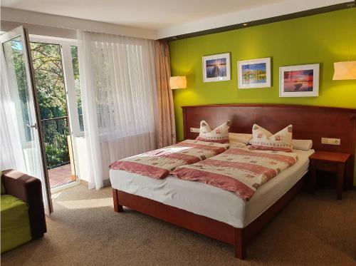 斯切尔采-克拉延斯凯Hotel Dlugie的一间卧室设有一张带绿色墙壁的大床