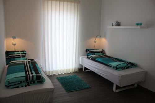 希尔克道夫Ferienhaus Heimathafen的一间卧室设有两张床和窗户。