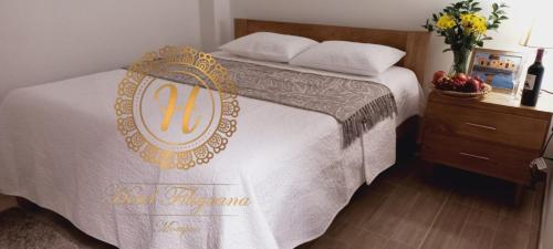 蒙波斯Hotel Filigrana Mompox的卧室配有一张带白色毯子和床头柜的床。