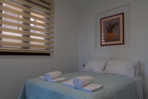 海若克利欧Chelidoni apartment ground floor的一间卧室配有一张床,上面有两条毛巾