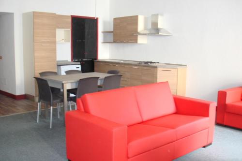 奥尔塔圣朱利奥Apartments Cabianchi的客厅配有红色的沙发和桌子