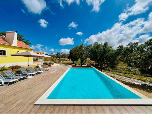 梅利迪什Celestial Melides Country House的一个带木甲板和蓝天的游泳池