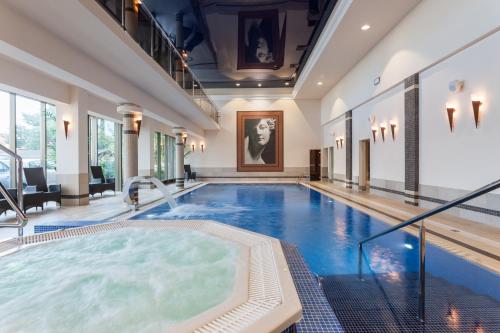 尤斯托尼莫斯基兰伯特Spa疗养酒店的大楼内带热水浴池的大型游泳池