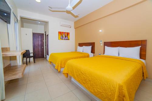 圣克鲁斯华特库Hotel Nonni的配有黄色床单的酒店客房的两张床
