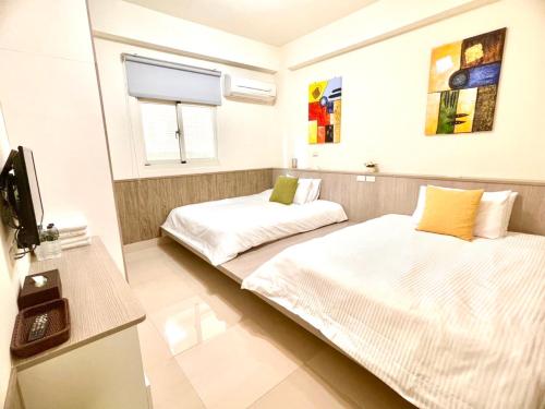 金宁乡八八古藝悅禾民宿的一间设有两张床和电视的房间