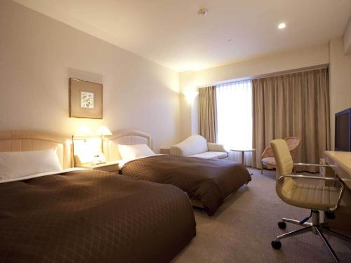 大分伦勃朗奥塔酒店的酒店客房配有两张床和一张书桌