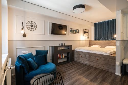 卢布尔雅那Strict city apartments的一间卧室配有一张床和一张蓝色椅子