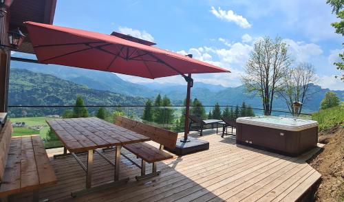 InnerschwandRuhige Bergvilla in Alleinlage am Mondsee mit Seeblick Bergblick und Whirlpool的甲板上设有热水浴池、野餐桌和遮阳伞