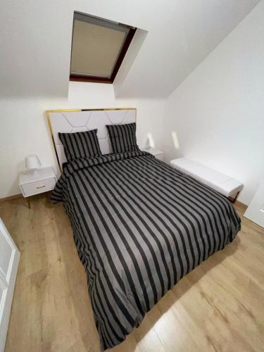 第戎Luxury suite maladiere 2的一间卧室配有一张带黑白条纹棉被的床