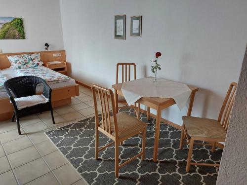 特里滕海姆Gästehaus Annette Hermes-Hoffmann的客厅配有桌椅和1张床