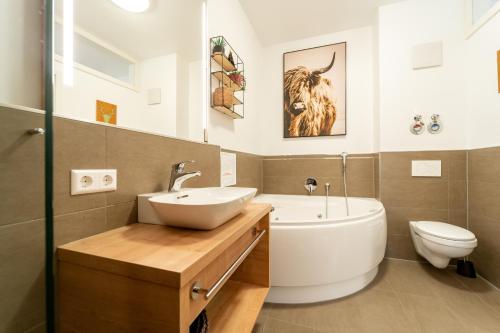 费尔德伯格Feldberg Lounge - Residenz Grafenmatt的一间带水槽、浴缸和卫生间的浴室