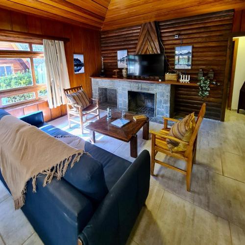 坎波斯杜若尔当Empório reserva da serra com área lazer natureza e excelente localização的客厅设有蓝色的沙发和壁炉