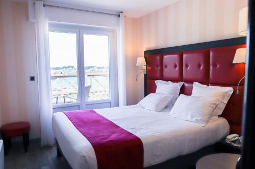 佩罗斯-吉雷克Logis Hôtel Saint Guirec Et De La Plage的一间卧室设有一张大床和一个窗户。