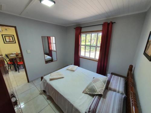 伊瓜苏港Cabañas Selva Verde的一间卧室设有一张床、一个窗口和一面镜子