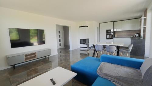日亚尔Apartmánový dom Žiar s vírivkou a saunou的客厅配有蓝色的沙发和桌子
