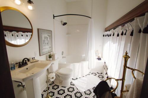 路易斯威尔Louisville Bourbon Inn的白色的浴室设有浴缸和水槽。