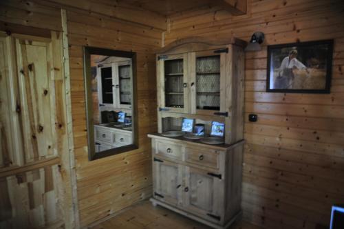 ZelaskoSzyszka i Róża Domek na Jurze的一间设有木墙的客房和一间带木制橱柜的厨房