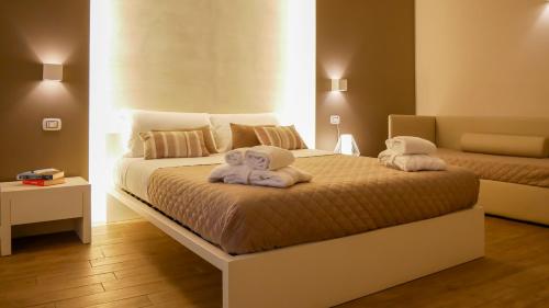 特拉尼La Banchina Holiday Rooms的一间卧室配有两张带毛巾的床