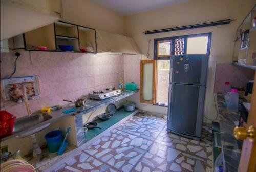 锡卡都Al Amin Guest House - Home away from Home的带冰箱的厨房和瓷砖地板。