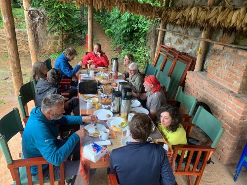 LushotoDavid Crater Homestay的一群坐在餐桌上吃食物的人