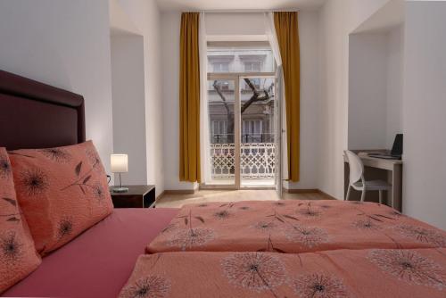 普拉Hostel Antique的一间卧室配有一张床、一个窗口和一张书桌