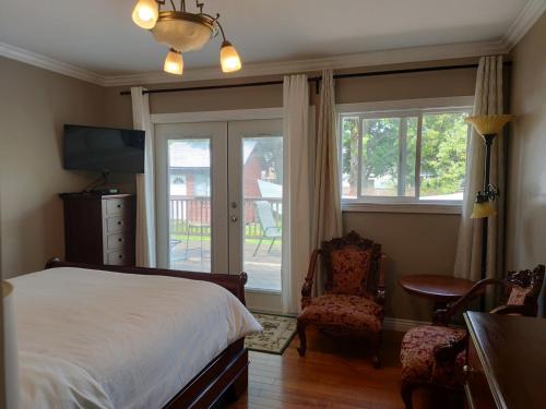 白石半中心房子酒店的一间卧室配有一张床、一把椅子和窗户。