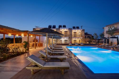 古瓦伊Volta Suites and Villas的一个带躺椅的游泳池和一个游泳池