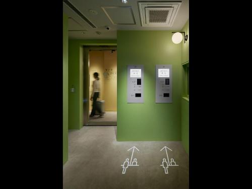 东京9h nine hours woman Shinjuku的一间拥有绿色墙壁和墙上绘图的房间