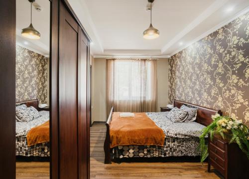 Nizhnyaya Alekseyevka马科斯酒店 的一间卧室配有两张床和镜子