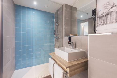 汉堡the niu Yen的浴室设有白色水槽和蓝色瓷砖
