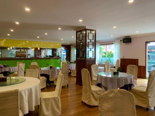 金边Chung Hsin Hotel 中信酒店的一间带桌椅的餐厅和一间厨房