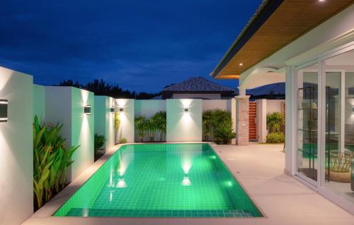 华欣My Orchid HuaHin的夜间房子后院的游泳池