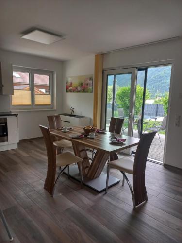 奥西亚歇尔湖畔施泰因多夫Ferienhaus Natura 2000的厨房以及带木桌和椅子的用餐室。