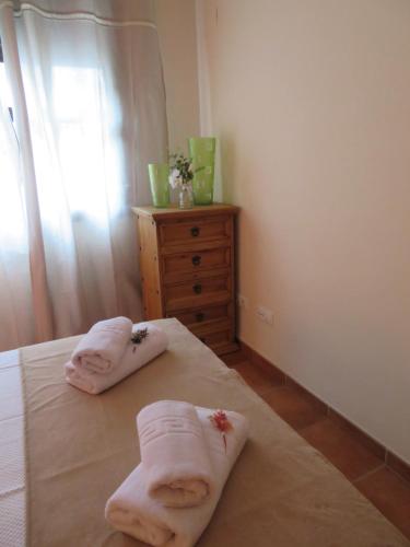 卡索拉ALOJAMIENTO YOLANDA CAZORLA的一间卧室,床上配有2条毛巾,床上配有梳妆台