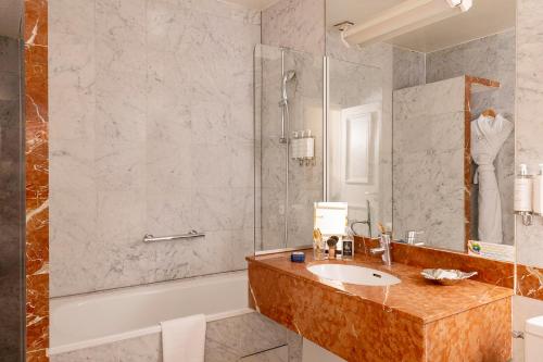 巴黎塞纳酒店的一间带水槽、浴缸和淋浴的浴室