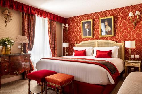 巴黎塞纳酒店的一间卧室配有一张带红色壁纸的大床