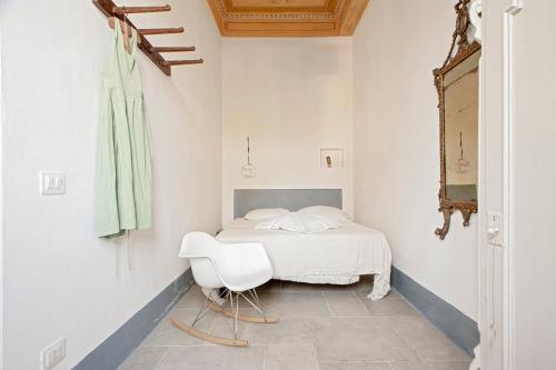 利沃诺Piéce en rose的卧室配有白色的床和白色椅子