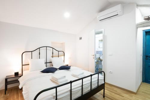 波尔托罗Istrian Casa Ladonia by Locap Group的一间卧室配有一张带白色床单和蓝色门的床。