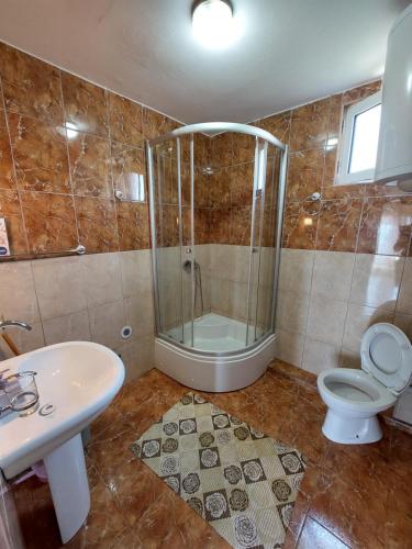 乌尔齐尼Apartments South的带淋浴、卫生间和盥洗盆的浴室