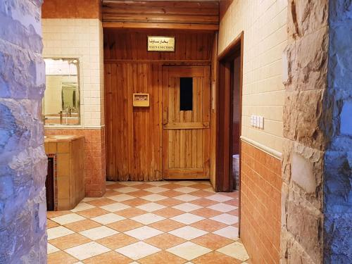 艾卜哈Shafa Abha Hotel的走廊设有木门,铺有瓷砖地板
