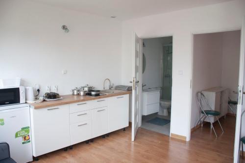 达洛科APARTAMENT i pokoje Aura Dom Wczasowy的厨房配有白色橱柜和水槽