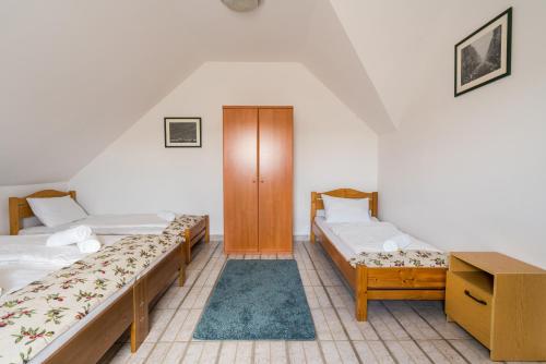 维拉尼Szeparé pinceház szállás Villány központi részén.的客房设有两张床和木制橱柜。