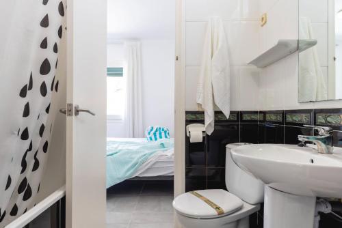 萨卡罗Bravissimo Vil·les Brusi A S'Agaró的一间带水槽和卫生间的浴室以及一张床