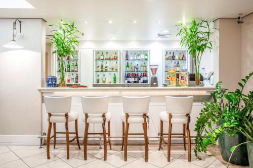 圣保罗韦博迪威诺联合国蓝树高级酒店的餐厅内带四张白凳的酒吧