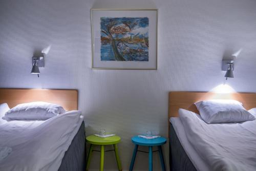 吕勒奥Sunderby folkhögskola Hotell & Konferens的带两张凳子的房间的两张床